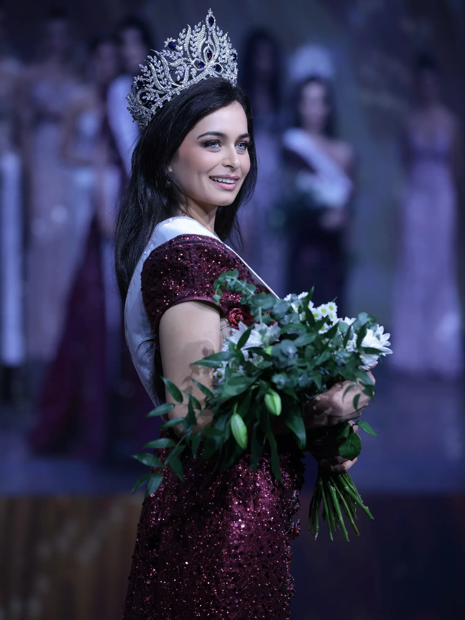 Itiya Dube, newly crowned Miss Universe Switzerland 2026, holding her bouquet on stage in Bern